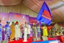 Politicians on a stage at an NDC special convention, with a large blue NDC flag waving in front of a purple backdrop that reads ‘NDC Special Convention 2026’