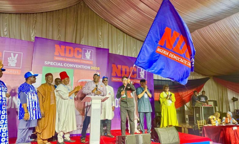 Politicians on a stage at an NDC special convention, with a large blue NDC flag waving in front of a purple backdrop that reads ‘NDC Special Convention 2026’