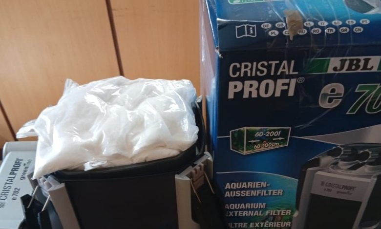 Water purifier - The Times of Abuja Box for a JBL CristalProfi aquarium filter beside a black canister filter with a white bag on top, on a shelf.