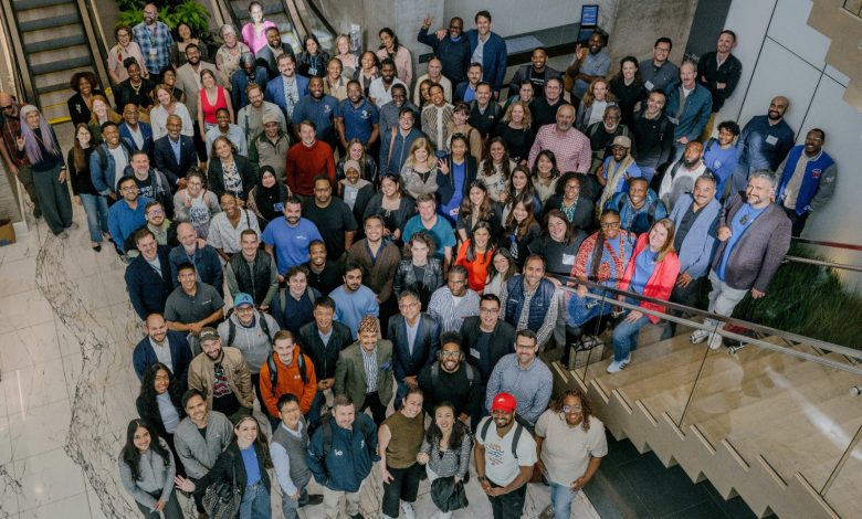 AWS Social Entreprenuer Accelerator_Cohort 4_2026JPG - The Times of Abuja Large diverse group posing for a team photo on a stairwell in a modern atrium, facing the camera and smiling.