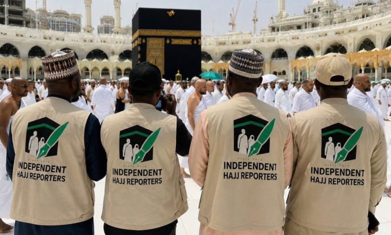 Independent Hajj Reporters - The Times of Abuja Four reporters wearing beige vests with an 'Independent Hajj Reporters' logo stand with their backs to the camera near the Kaaba in Mecca during Hajj.