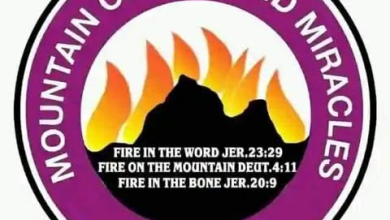 Logo for Mountain of Fire and Miracles Ministries: a purple circular emblem with white edge text around a black mountain and orange flames, featuring Bible verses Jeremiah 23:29; Deuteronomy 4:11; Jeremiah 20:9 in the center.