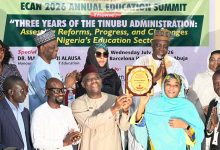 Group of people on stage at an education summit award ceremony, banner behind reads ECAN 2026 Annual Education Summit with a plaque being handed to a woman in turquoise hijab and scarf.