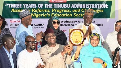 Group of people on stage at an education summit award ceremony, banner behind reads ECAN 2026 Annual Education Summit with a plaque being handed to a woman in turquoise hijab and scarf.