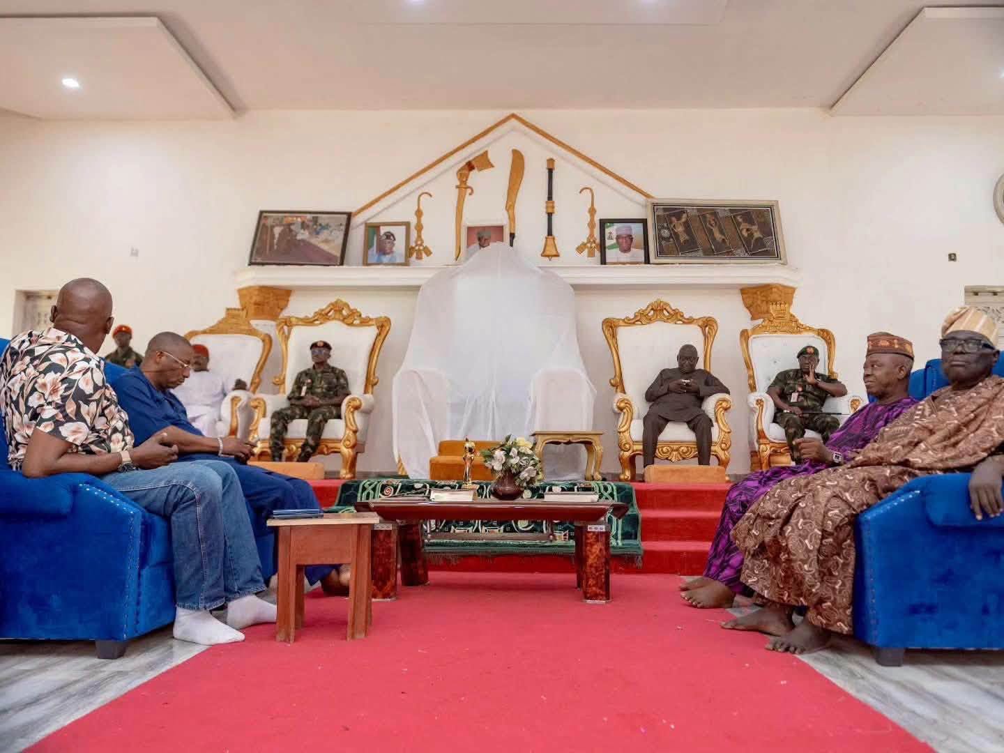 Inspection of Kwara battalion camp site 3 - The Times of Abuja Formal gathering with dignitaries seated on gold chairs around a white-draped central display, suggesting a ceremony or funeral.