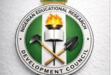 Logo of the Nigerian Educational Research Development Council: a green‑white‑green circular emblem with a burning torch over an open book and crossed hammer and shovel, surrounded by the organization’s name.