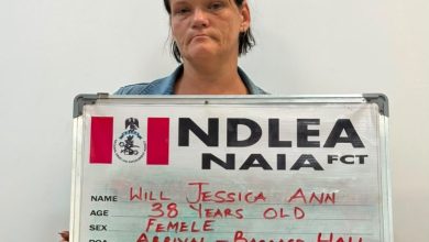 Mugshot of a woman holding a metal ID board with handwritten personal details: name Will Jessica Ann, age 38, female, drug heroin.