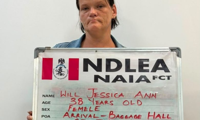 Mugshot of a woman holding a metal ID board with handwritten personal details: name Will Jessica Ann, age 38, female, drug heroin.