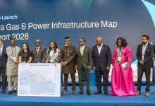 Group of diverse professionals on a blue stage posing with a large Nigeria Gas & Power Infrastructure Map during a strategic launch event.