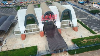 Aerial view of a modern bus terminal with three curved white arches and a covered ramp, signage reads 'Central Business District Bus Terminal'.